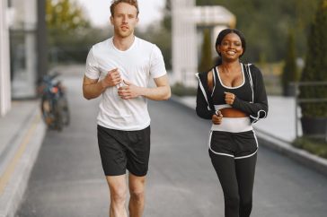 A man and woman jogging together outside, embracing a healthy lifestyle.